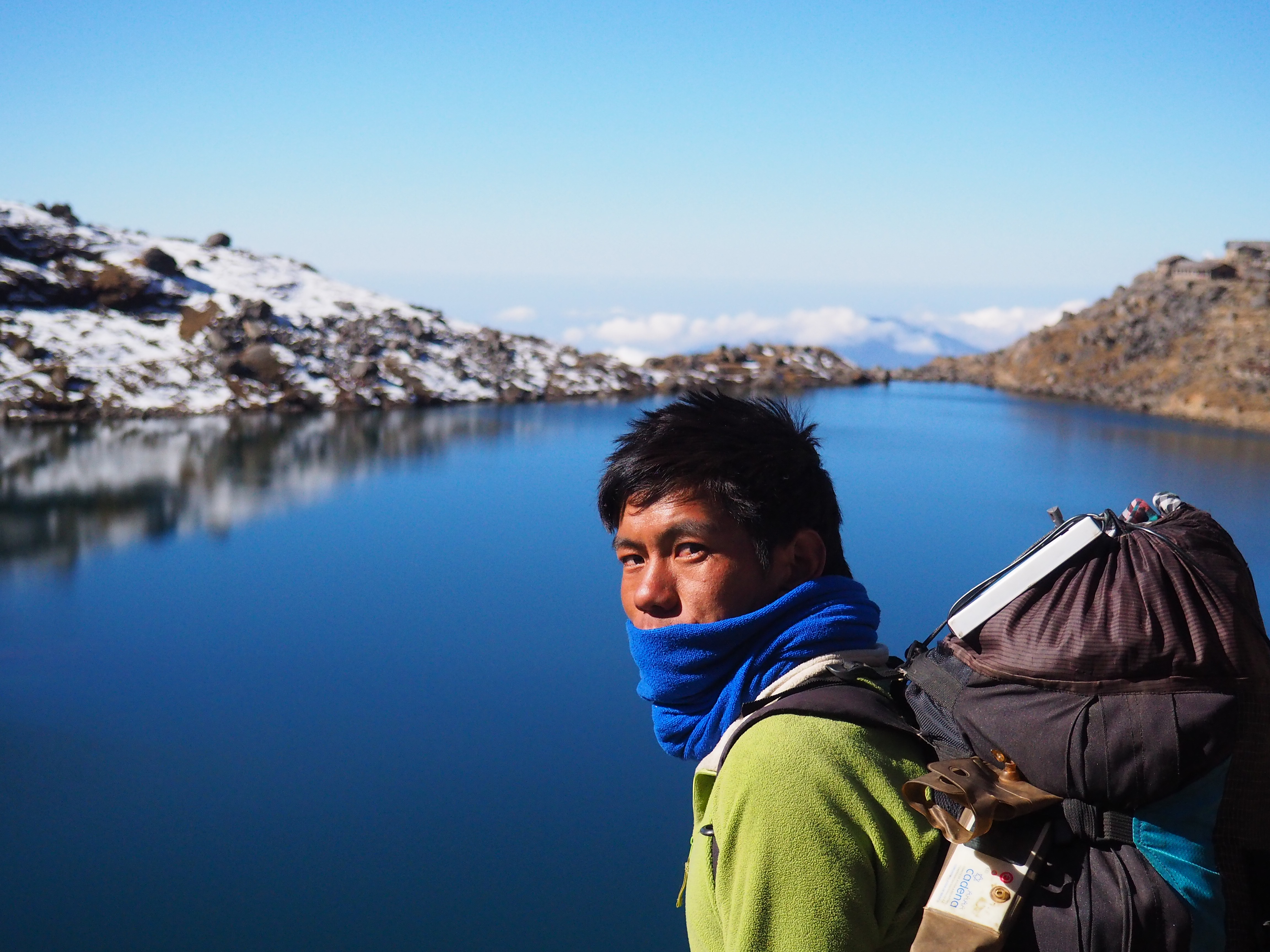 A man looks over his shoulder at the camera while standing over 
                    a lake